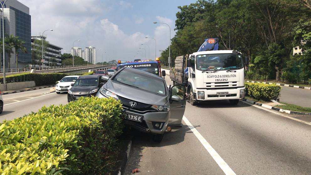 Car mounts road divider, knocks over road sign along Braddell Road Viaduct