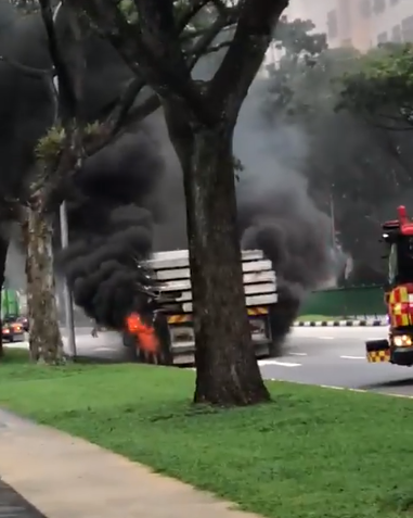 浓浓黑烟！大型拖车在路旁着火，消防员火速前往灭火！