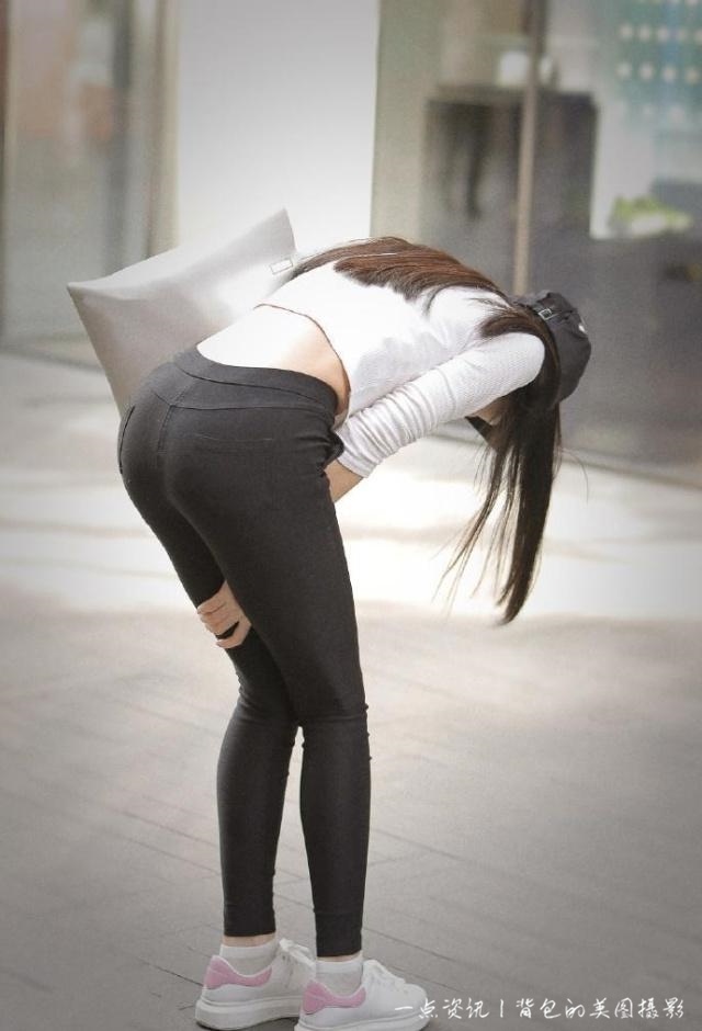 街拍，美女黑色紧身裤显得玲珑可爱，整体穿搭透出迷人的少女气息