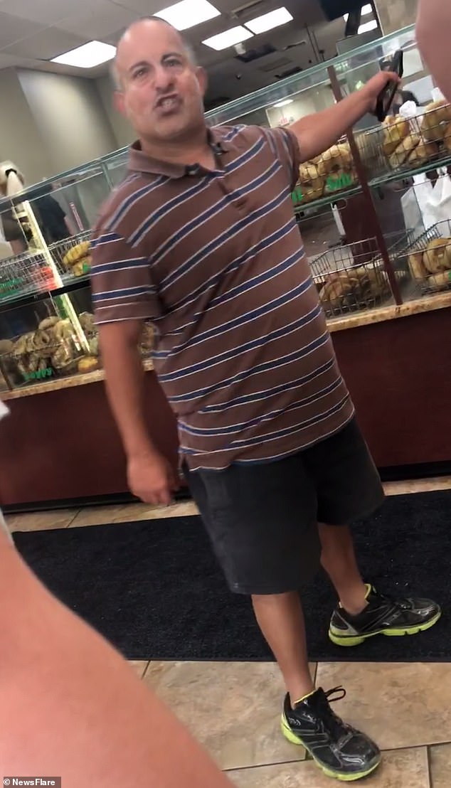 Short tempered! Man goes on a furious rant in bagel shop about women 'hating men under 5ft' before he challenges a customer twice his size to a fight who promptly tackles him to the ground