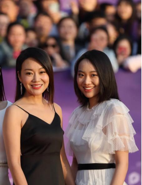 闫妮一袭吊带裙出席活动，竟被身边的女儿给抢镜：这是对姐妹花吧