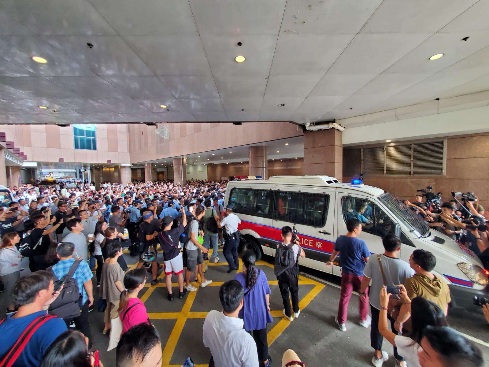 尖沙嘴唱国歌游行爱国人士被市民包围 警方护送上警车离开