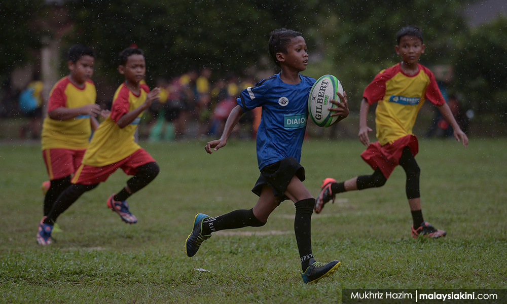 SK Bukit Lanjan rugby team carries the ball for Orang Asli