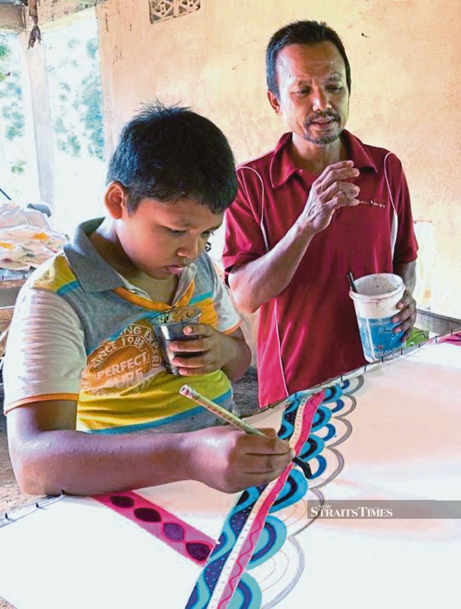 Boy helps dad in home-based batik printing biz