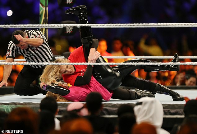 WWE star Natalya is hit with a BOTTLE while making her entrance in Saudi Arabia's first female wrestling match, as she and opponent Lacey Evans ditch bikini tops for T-shirts