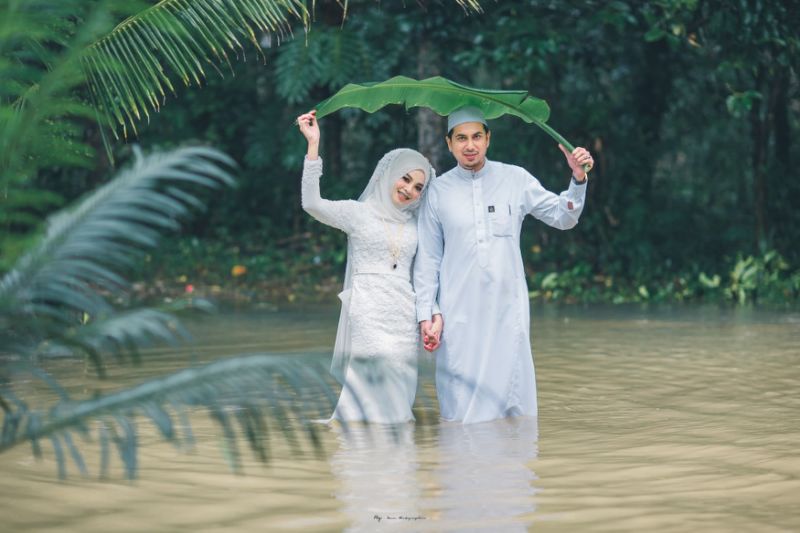 Couple in southern Thailand pose in knee-deep floodwater for wedding photoshoot during monsoon season