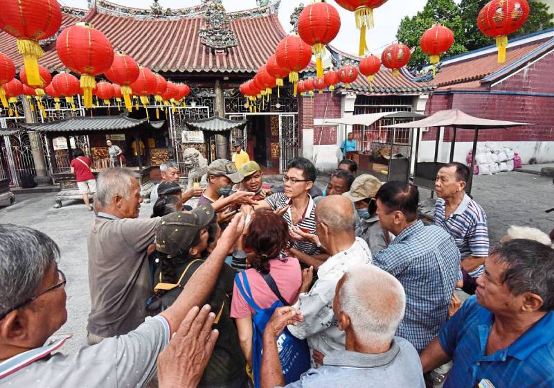 Malaysian man handing out donation at temple is mobbed by 'habitual beggars'