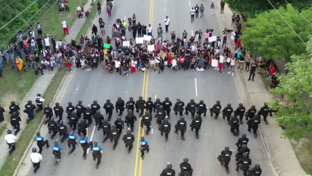 US police stun protesters during standoff as 60 officers kneel in support of George Floyd