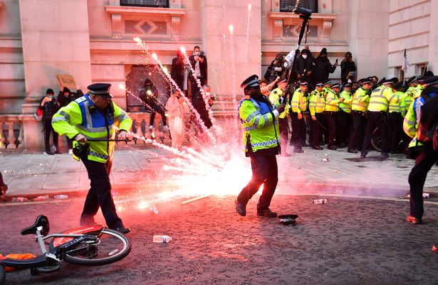 Brave woman steps in front of protest crowds to stop objects being hurled at police