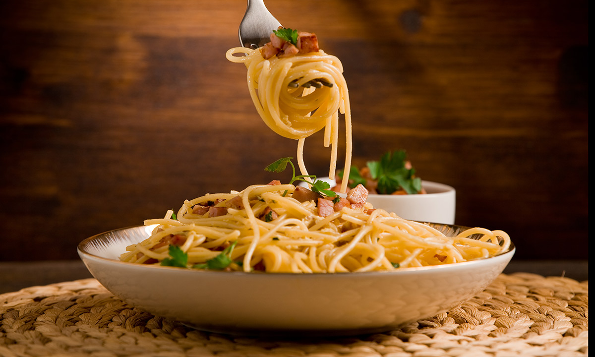 Spoon or no spoon for spaghetti? A top etiquette coach reveals the CORRECT way to eat pasta