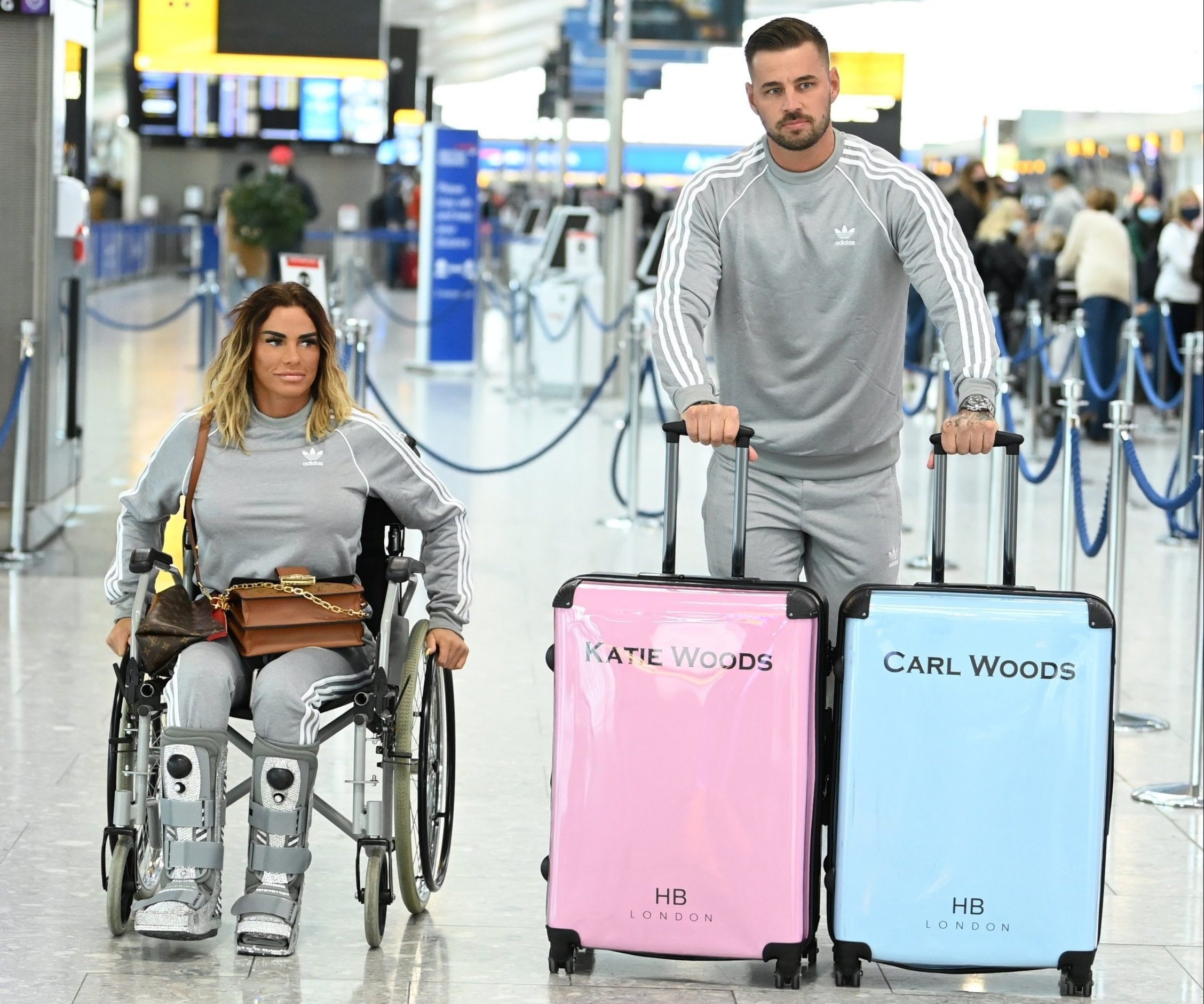Katie Price and Carl Woods show off matching ‘Woods’ suitcases and identical tracksuits as they jet off to the Maldives