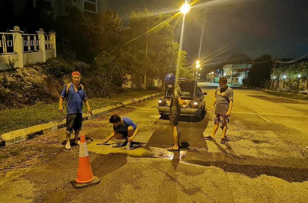Fed up with potholes, Bercham residents in Ipoh patch road up themselves
