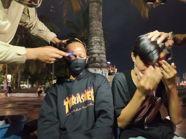 Police officers punish teens by shaving off their eyebrows after parking fee scam