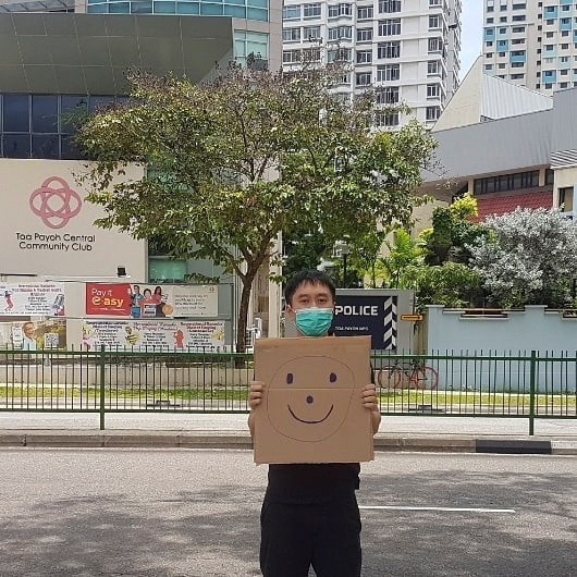 Singapore activist faces fine over one-man smiley face sign protest