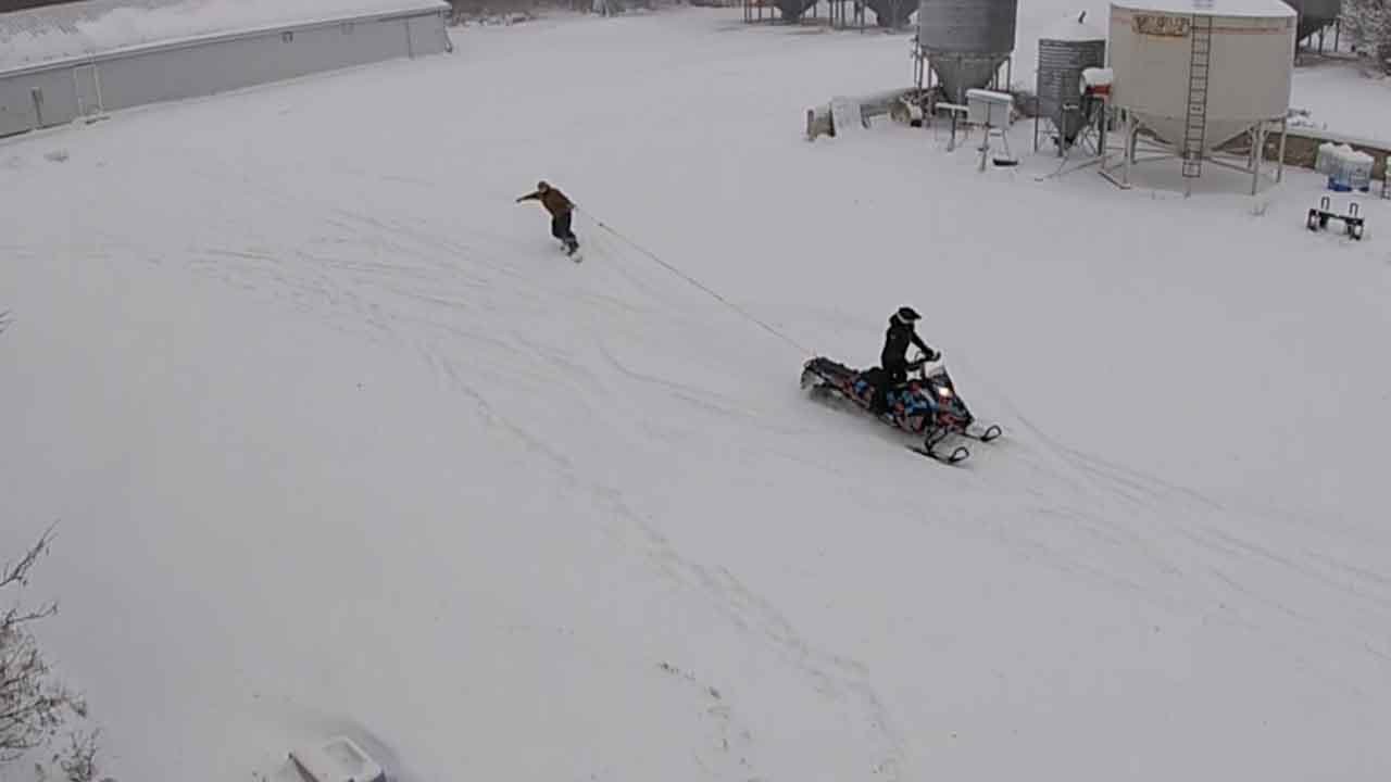Guy Goes Snowboarding Using A Snowmobile