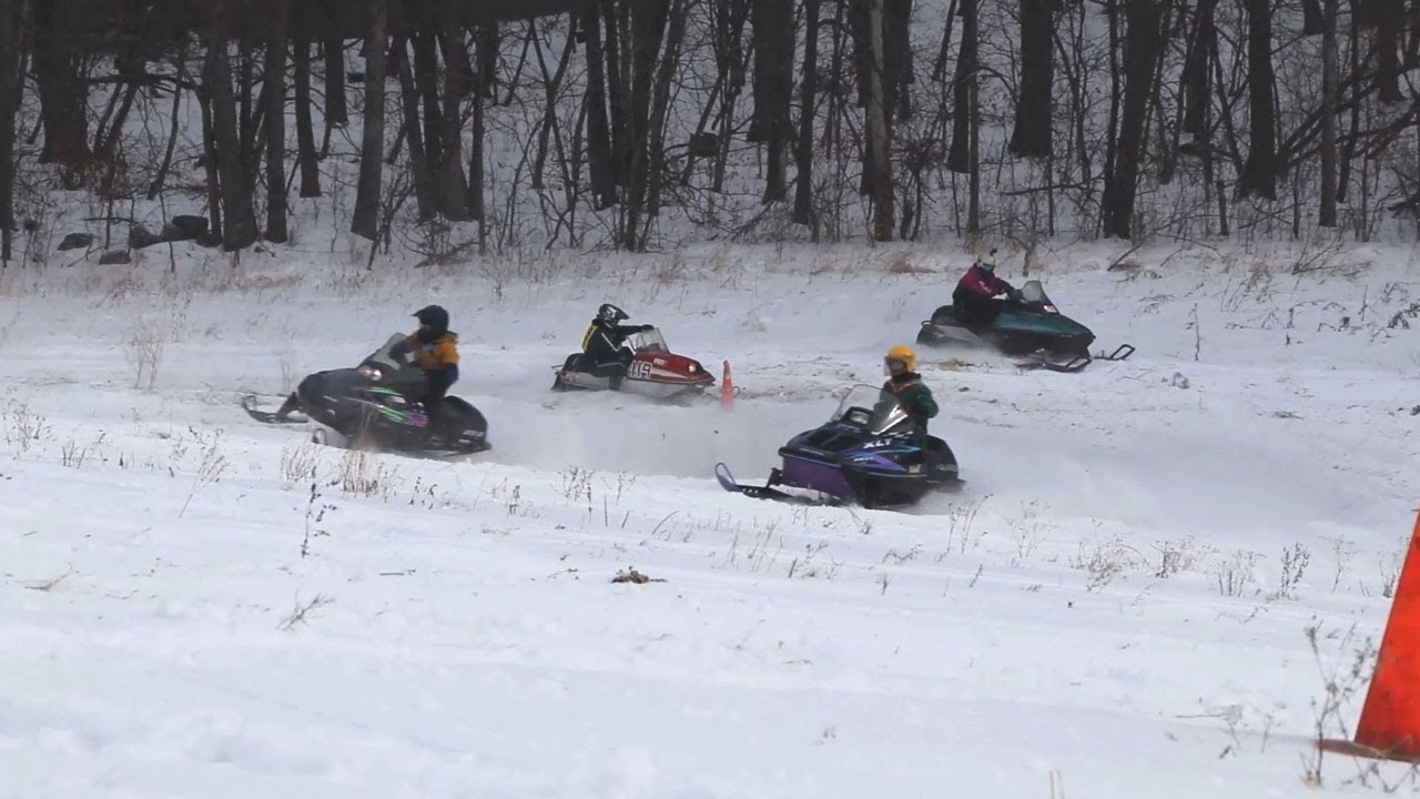 Friends Race Against Each Other On Old Snowmobiles