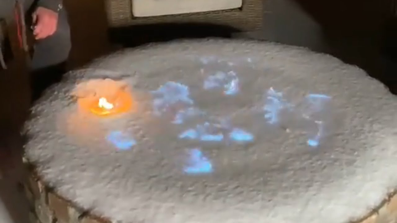 Guy Lights Frozen Fire Pit At the Back Porch Of His House