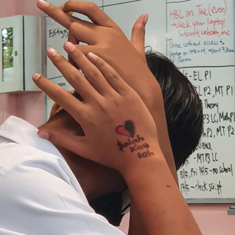 Young punk use marker draw 369 gang angkong on his hand, flash gang sign