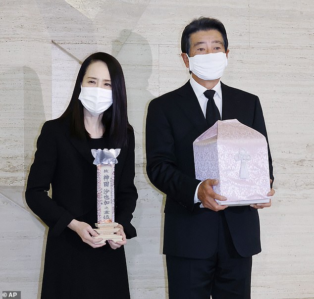 Heartbroken parents of Japanese Frozen actress who fell to her death from a hotel hold her ashes after she is cremated as they 'say goodbye' as police investigate suspected suicide