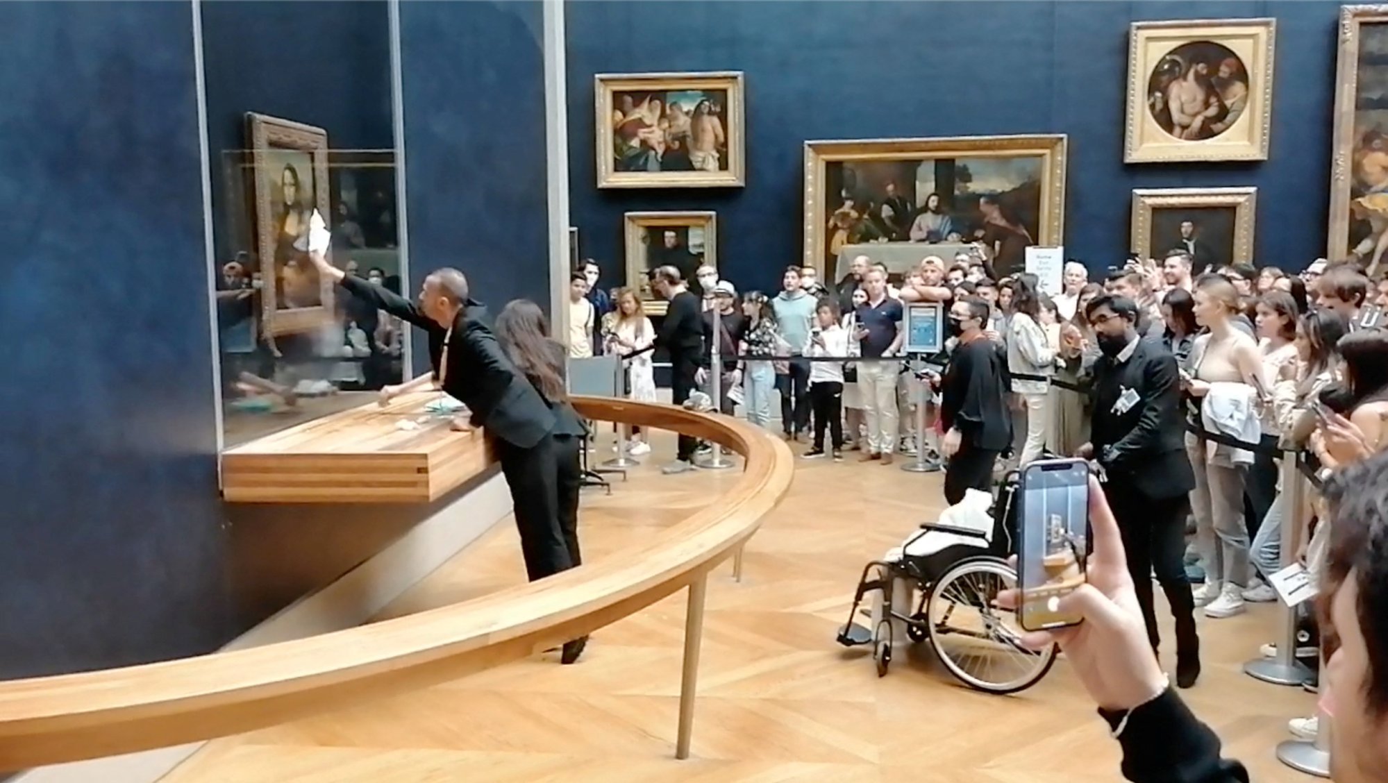 Man disguised as an old woman throws cake at the Mona Lisa in Paris