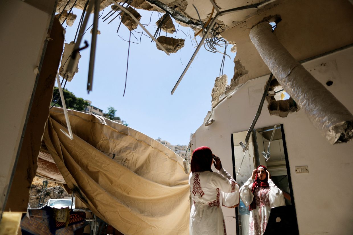 A Palestinian bride celebrates in the rubble of her demolished Jerusalem home