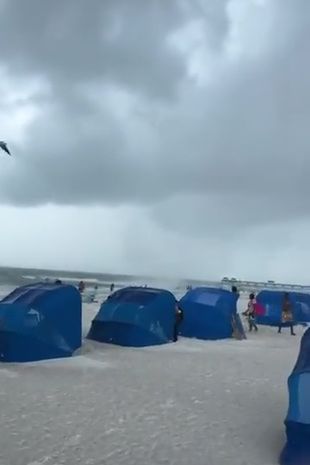 Terrifying moment beachgoers flee Florida shoreline as waterspout spins out of control