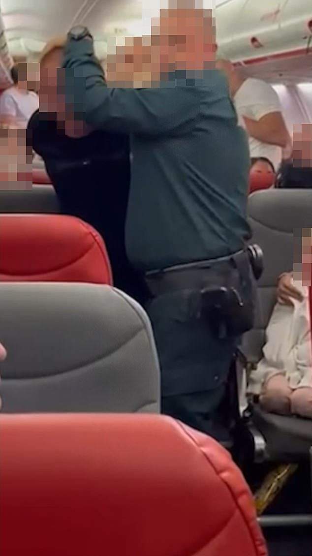 Moment raging 'British' holidaymaker 'who tried to open door' of packed plane waiting to take off from Croatia is tackled by passengers before being led away and arrested
