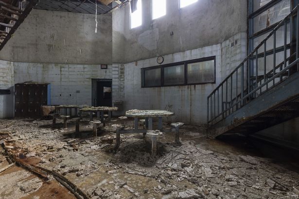 Inside abandoned juvenile detention centre with crumbling walls and rotting mattresses