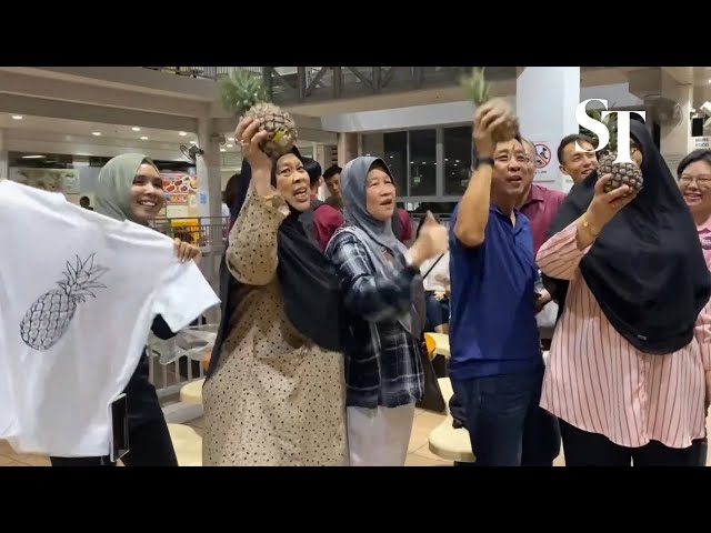 Tharman supporters arrive at Taman Jurong Food Centre with chants and pineapples