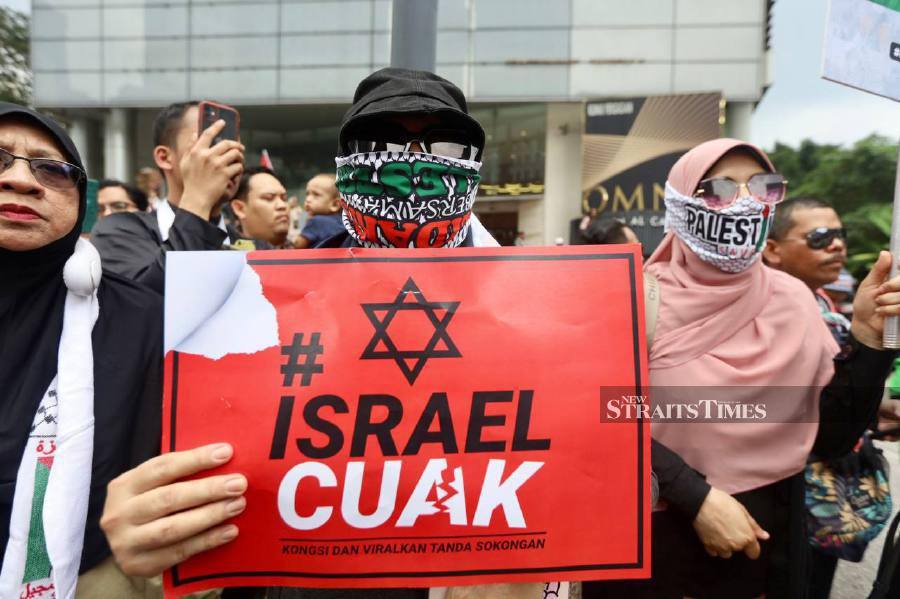 Protesters in white and Palestinian keffiyehs march to condemn deadly Gaza hospital attack, US support for Israel