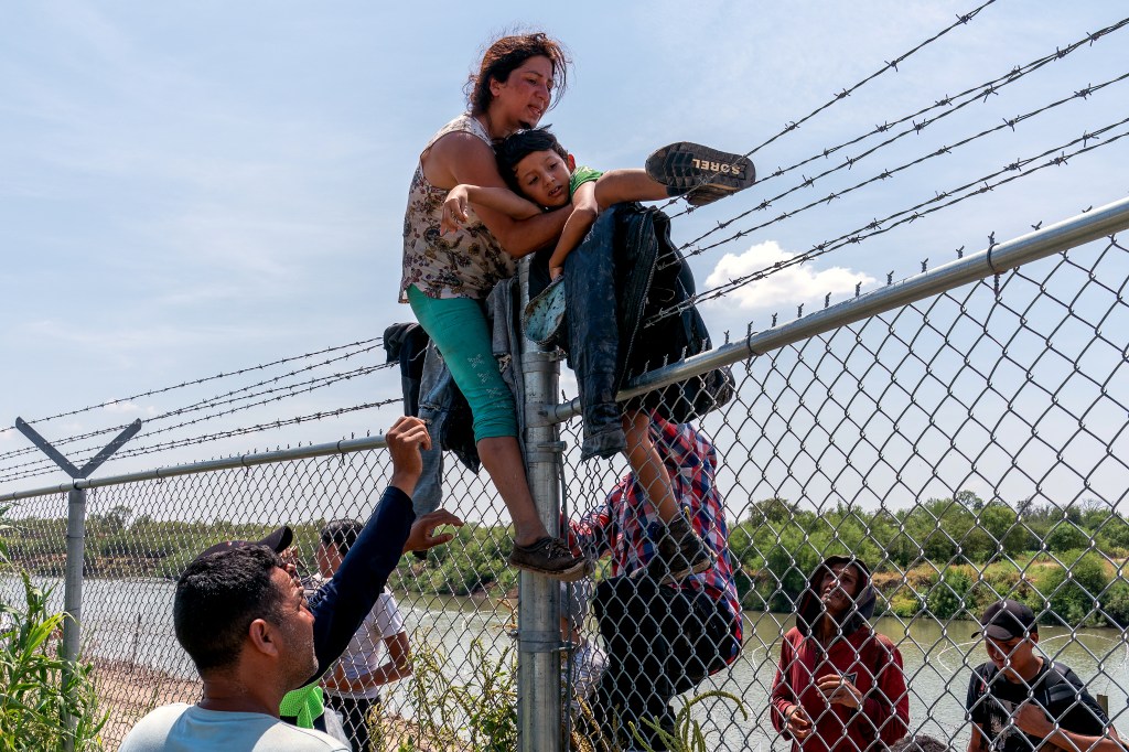 Drone footage shows hundreds of migrants crossing Rio Grande and crawling through wire at the southern border