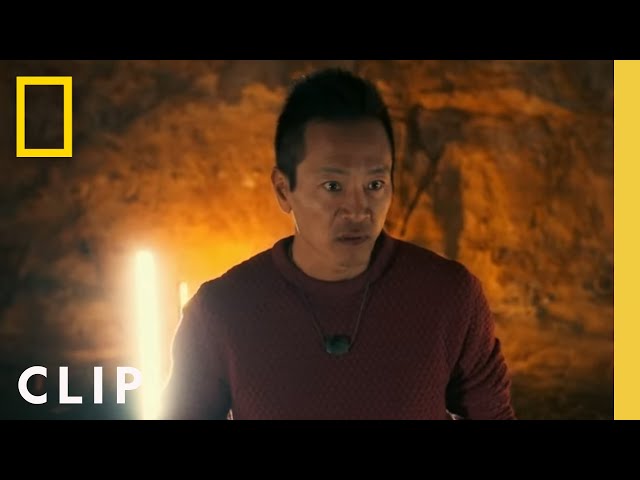 Explorer Albert Lin explores a cave burial site filled with ancient carvings