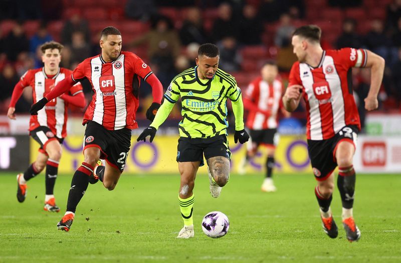 Soccer-Arsenal hit Sheffield United for six to keep pace with leaders