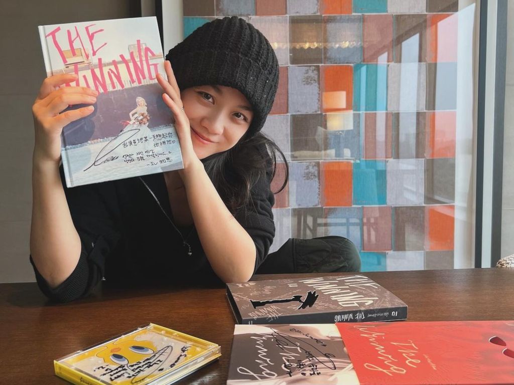 Tang Wei shows off signed copy of IU's "The Winning"