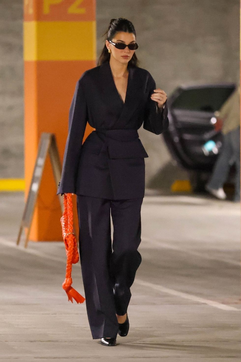 Kendall Jenner Accents Her Quietly Cool Navy Blue Suit With a Bright Orange Bag