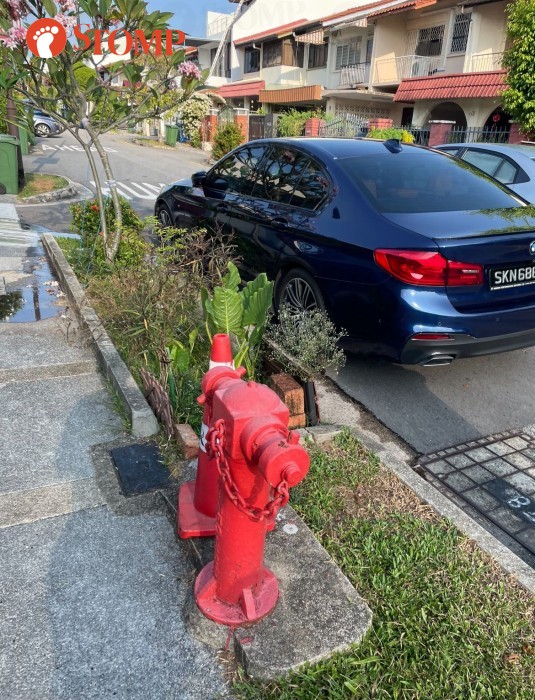 BMW owner uses safety cone with LTA logo to chope parking space next to hydrant in Bedok private estate